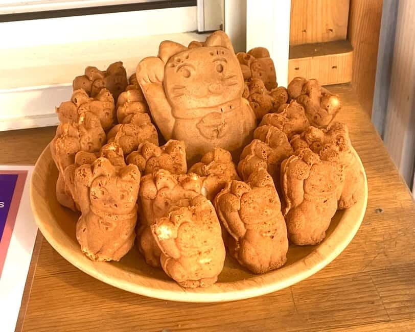 Tokyo: Gotokuji Lucky Cat Temple & Harajuku Cat Cafe Tour - The Gotokuji shopping street, cat items you can actually take home